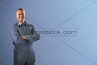 Mechanic standing in front of a blue background