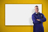 Mechanic standing in front of a white screen on yellow background