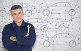 Mature mechanic standing in front of a cars diagram background