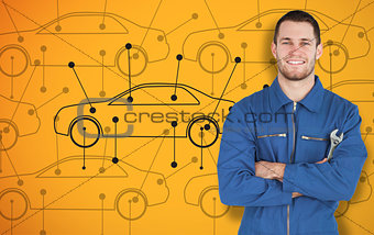 Young smiling mechanic standing in front of cars background