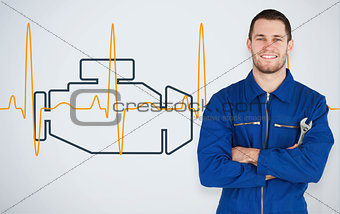 Portrait of a young mechanic next to background with car engine and heart line