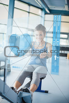Young girl doing rowing machine with futuristic interface
