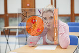 Blonde woman thinking hard while studying on interface with brain
