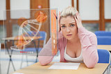 Blonde woman thinking hard while studying on interface with DNA