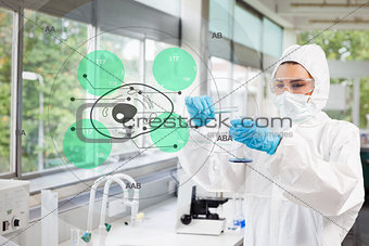 Scientist in protective suit working with green cell diagram interface