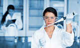 Serious chemist working with large pipette and test tube