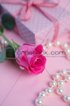 Pink rose with gift and pearls