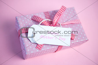 Pink gift wrapped box with happy mothers day tag