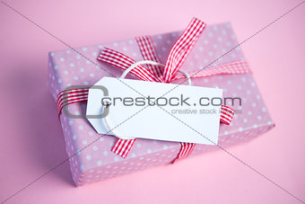 Pink gift wrapped box with blank tag