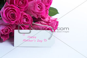 Bouquet of beautiful roses with happy mothers day card on a table