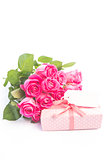 Bouquet of roses next to a gift with a blank card