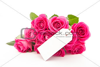 Close up of a beautiful bouquet of pink roses with an empty card on a white background