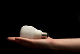 Hand holding white economic light bulb