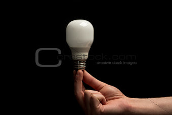 Man holding economic light bulb in his fingertips