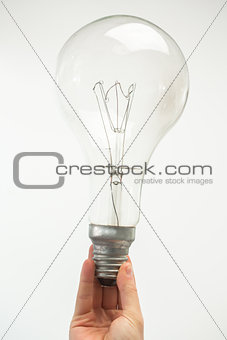 Man holding big light bulb at his fingertips close up