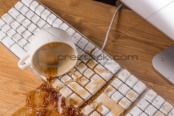 Cup of tea spilling over a keyboard