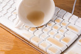 Cup of tea spilled out over a keyboard close up
