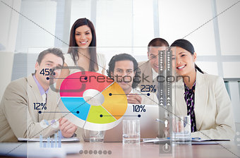 Smiling business workers looking at colorful pie chart interface