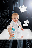 Baby holding jigsaw piece sitting on white reflective surface