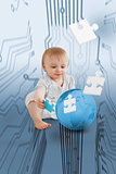 Baby holding jigsaw piece sitingt next to a globe