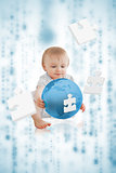 Cute baby holding a blue planet with jigsaw pieces floating around him