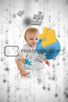 Jigsaw pieces floating around a cute baby playing with a blue planet