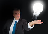 Light bulb lighting up inside the hand of businessman
