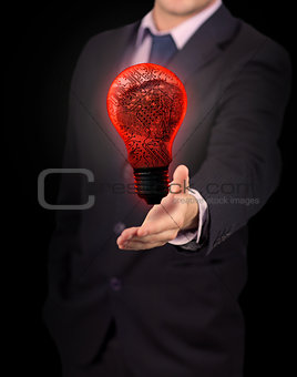 Businessman holding red light bulb