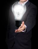 Businessman holding big light bulb lighting
