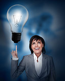 Businesswoman looking up at the big light bulb