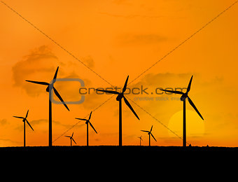 Several wind turbines with a sunset