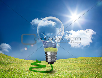 Light bulb showing solar panels and turbines in a field