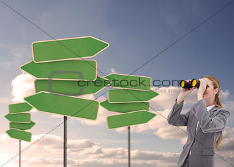 Businesswoman looking at empty signposts with binoculars