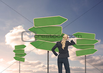 Rear view of a businesswoman looking at empty signposts