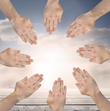 Group of hands forming a circle over blue sky