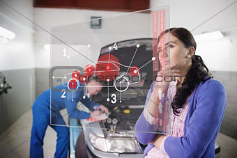 Auto mechanic with customer looking at futuristic interface