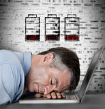 Businessman sleeping on his laptop with no battery symbols