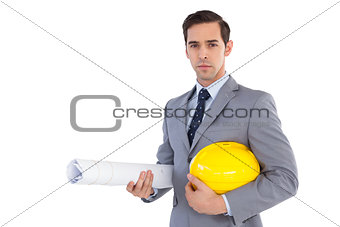 Serious architect holding plans and hard hat