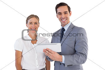 Smiling co workers using a tablet pc