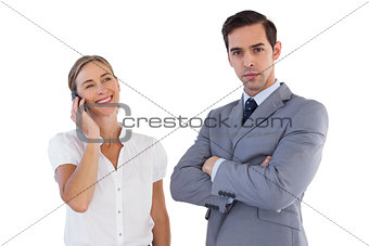 Smiling businesswoman on the phone next to her colleague