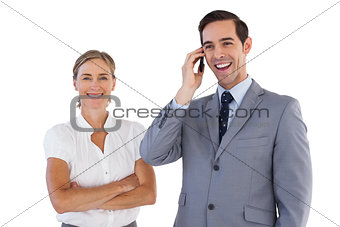 Smiling businessman on the phone next to his colleague