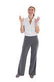 Cheerful businesswoman standing with raised hands