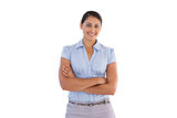 Smiling businesswoman standing alone with her arms crossed