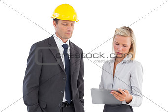 Two architects looking at clipboard