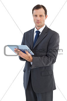 Serious charismatic businessman holding a tablet computer