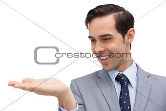 Businessman looking at and showing his opened hand