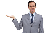 Smiling businessman presenting something with his hand