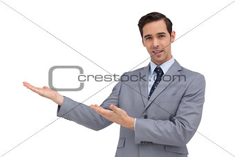 Smiling young businessman giving a presentation with his hands