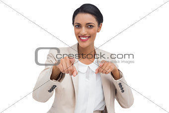 Smiling businesswoman pointing at the camera