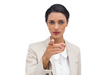 Serious businesswoman pointing at camera